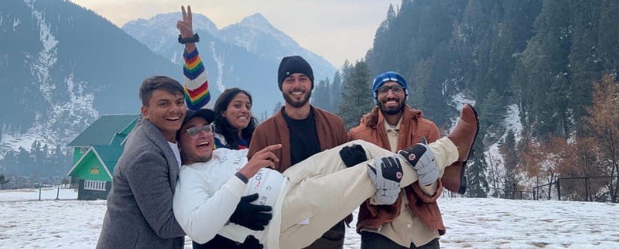 Friends lifting one of the group in a snowy valley